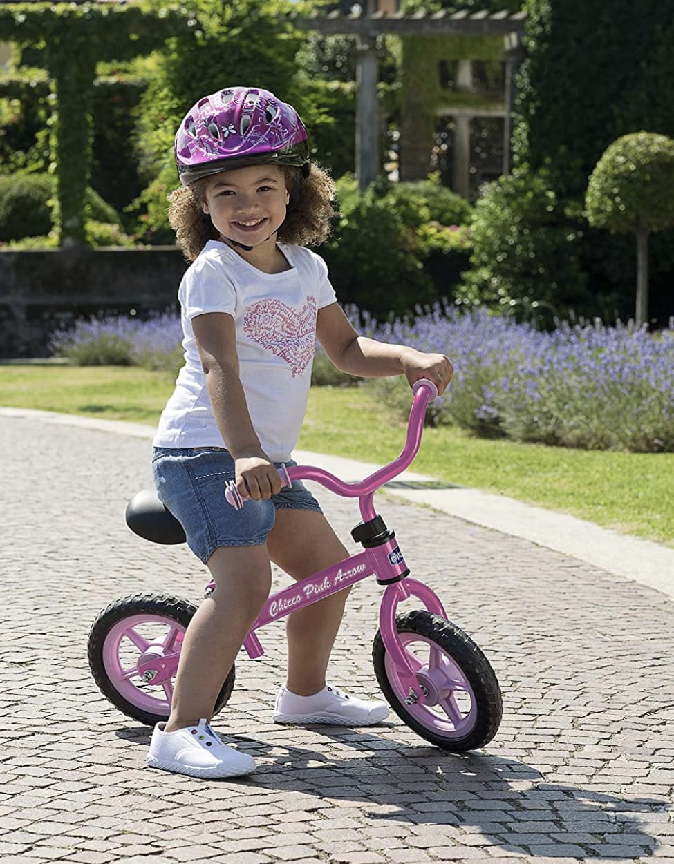 Niña sobre su bicicleta sin pedales Chicco rosa