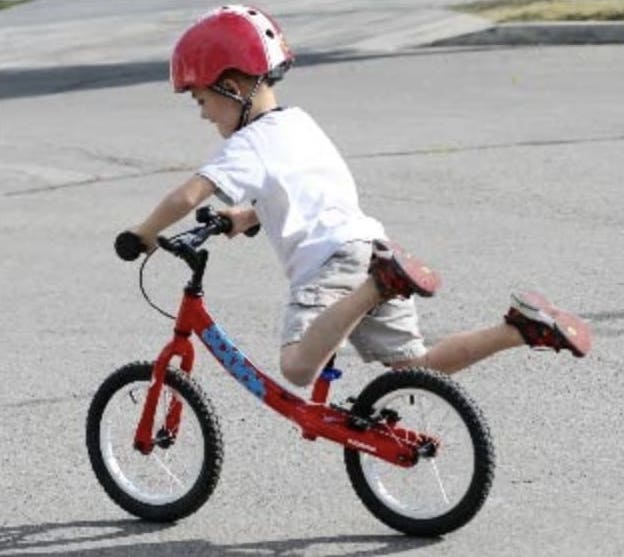 Niño deslizándose con su bicicleta son pedales